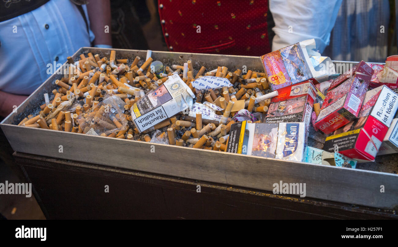 Zigarette Zigaretten liegen in einem großen Aschenbecher auf dem Oktoberfest-Gelände in München, Deutschland, 18. September 2016. Foto: Peter Kneffel/dpa Stockfoto
