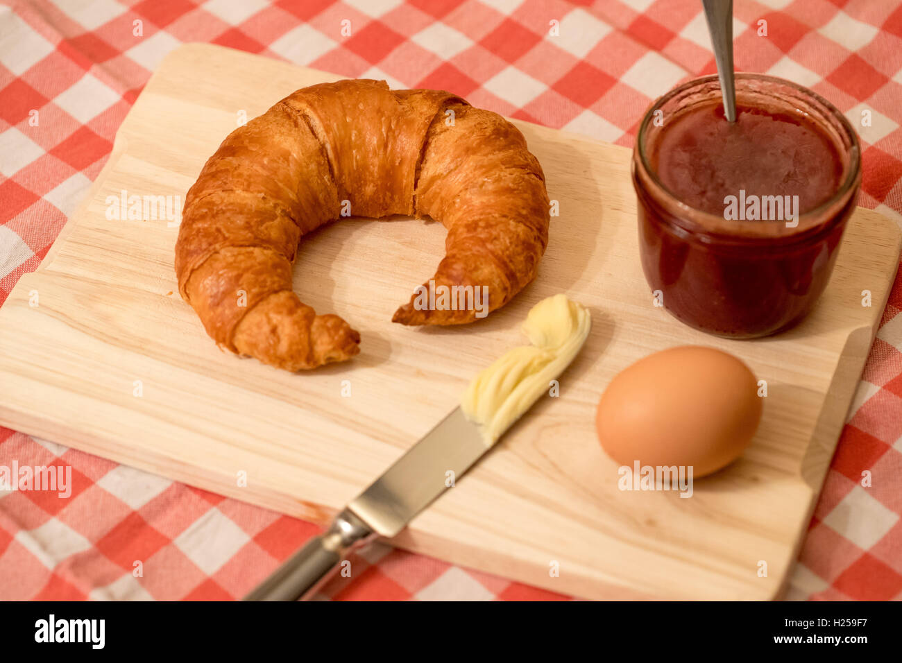 Nürnberg, Deutschland. 22. Sep, 2016. ILLUSTRATION - liegt ein Bamberg "Hoernla" auf ein Schneidebrett mit einem Messer mit Butter, Erdbeermarmelade und ein gekochtes Ei in Nürnberg, 22. September 2016. Foto: Daniel Karmann/Dpa/Alamy Live News Stockfoto