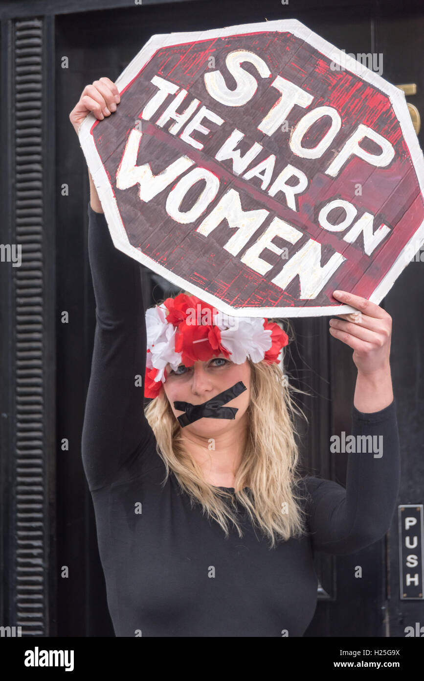 London, UK. 24. Sep, 2016. Ein polnischer feministische steht mit ihrem Mund versiegelt mit schwarzem Klebeband mit einem Schild "Stop Krieg gegen Frauen" bei der Protest in der polnischen Botschaft in Solidarität mit der 5. jährlichen März zur Wahl in Irland gegen die strengen Anti-Abtreibung Gesetze es verurteilt von der UNO als "grausame, unmenschliche und erniedrigende". In Polen MPs in das konservative Recht und Gerechtigkeit (PiS) Partei unterstützen einen Gesetzentwurf vorgelegt von der Lobby der Abtreibung zu stoppen, die Abtreibungen außer wo das Leben der Mutter gefährdet geahndet wird, 3 bis 5 Jahre im Gefängnis war machen würde. Bildnachweis: Peter Marshall/Alamy Live Ne Stockfoto