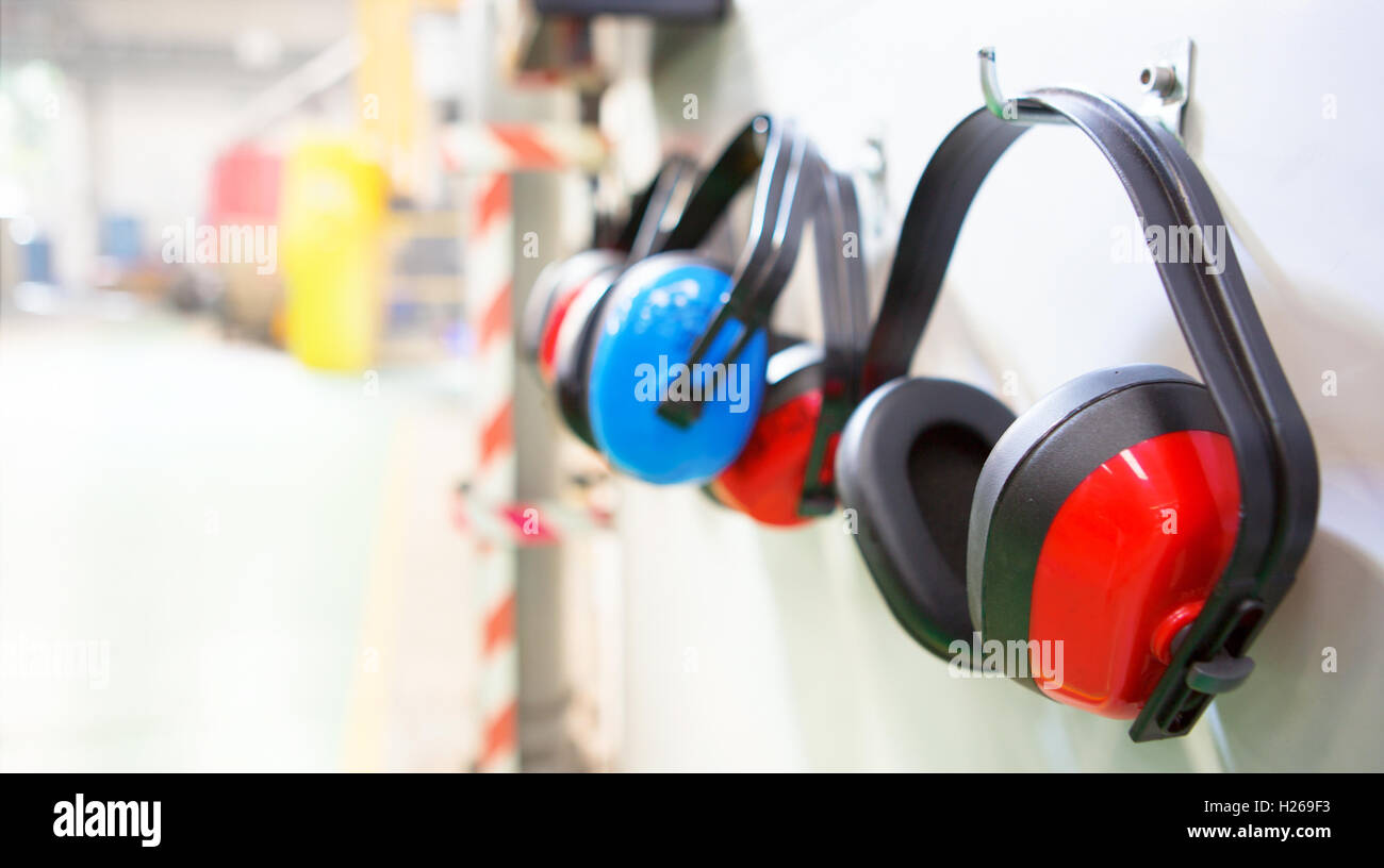 Reihe von Gehörschutz aufgehängt in einer Fabrik mit Textfreiraum Stockfoto