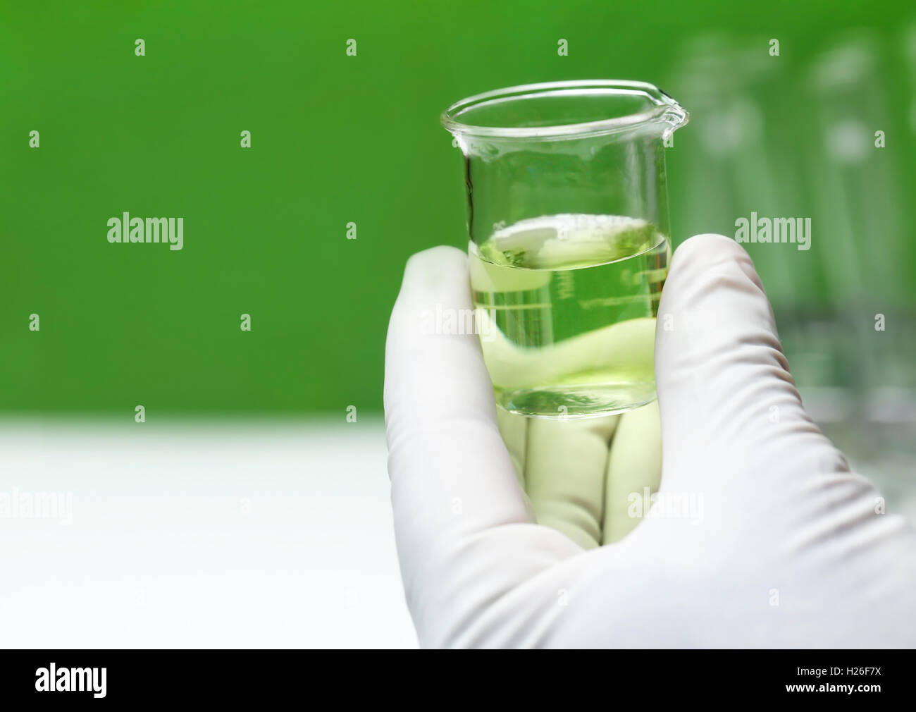 Hand hält einen Becher in Chemie-Labor Stockfoto