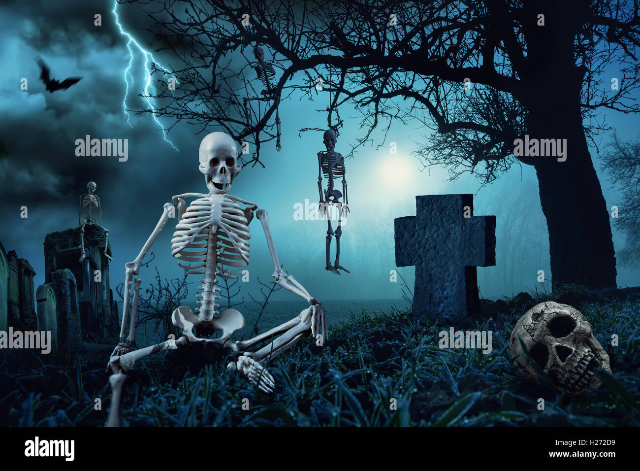 Halloween-Nachtszene mit Skeletten auf einem Friedhof und die Silhouette eines Toten Baumes im blauen Mondlicht Stockfoto