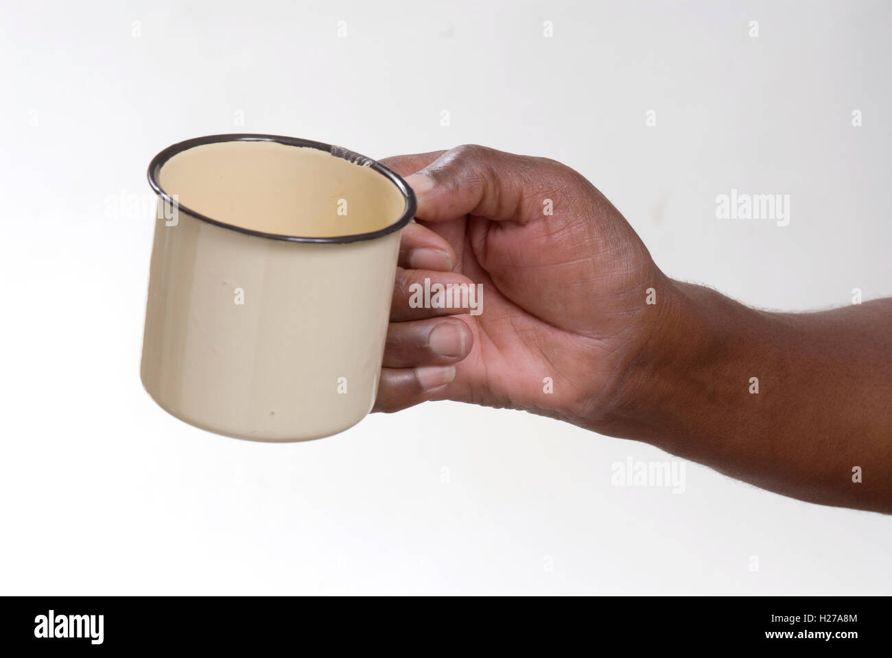 Afrikaner Hand hält eine leere emaillierten Zinn Becher könnte betteln oder bitten um Getränke oder Essen Stockfoto