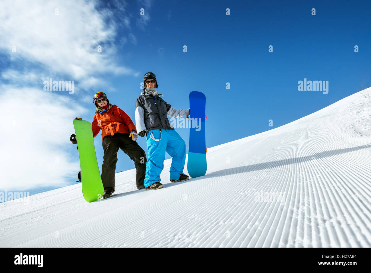 Snowboarder posiert auf blauen Himmel Hintergrund in Schneeberge Stockfoto