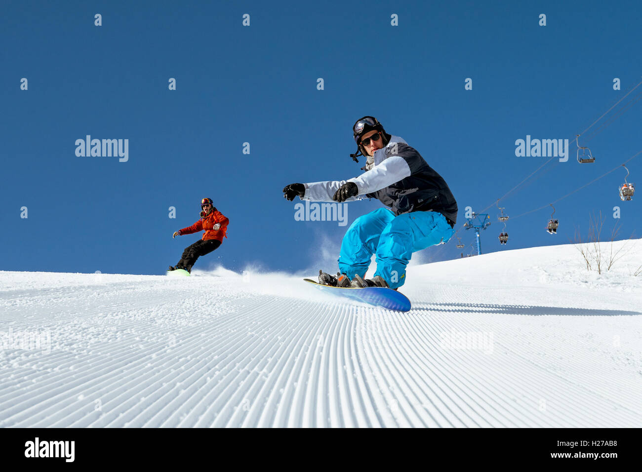 Snowboarder fahren auf blauen Himmel Hintergrund in Bergen Stockfoto