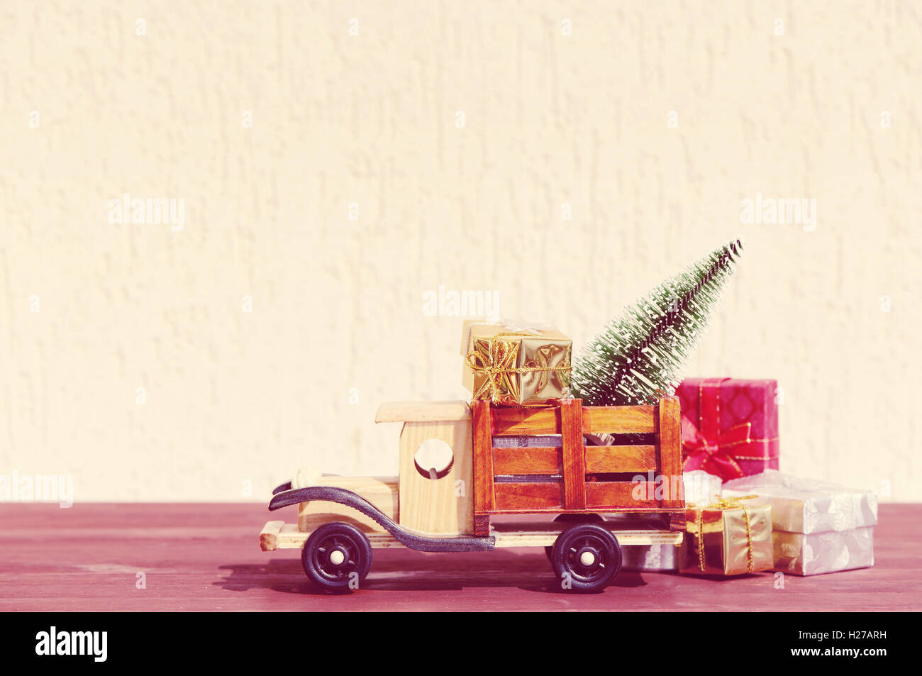 Weihnachten Hintergrund. Spielzeugauto LKW trägt Geschenke und einen Weihnachtsbaum. Stockfoto