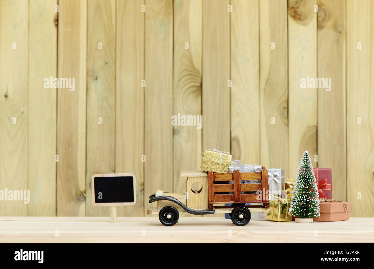 Weihnachten Hintergrund. Spielzeugauto LKW trägt Geschenke und einen Weihnachtsbaum. Stockfoto