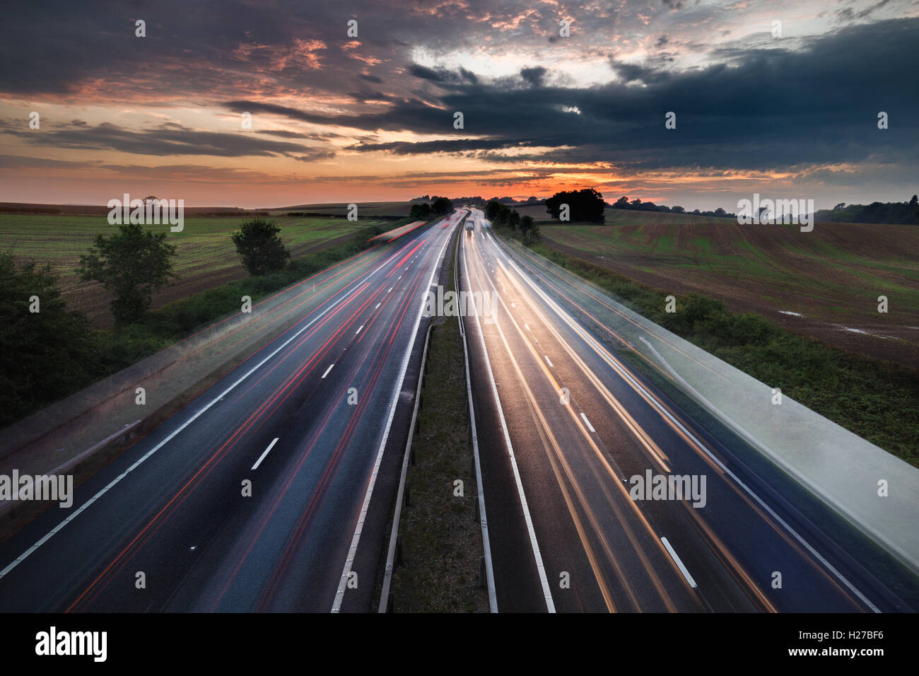 Autos in Bewegung auf stark frequentierten Autobahn mit bunten Dämmerung Himmel Stockfoto