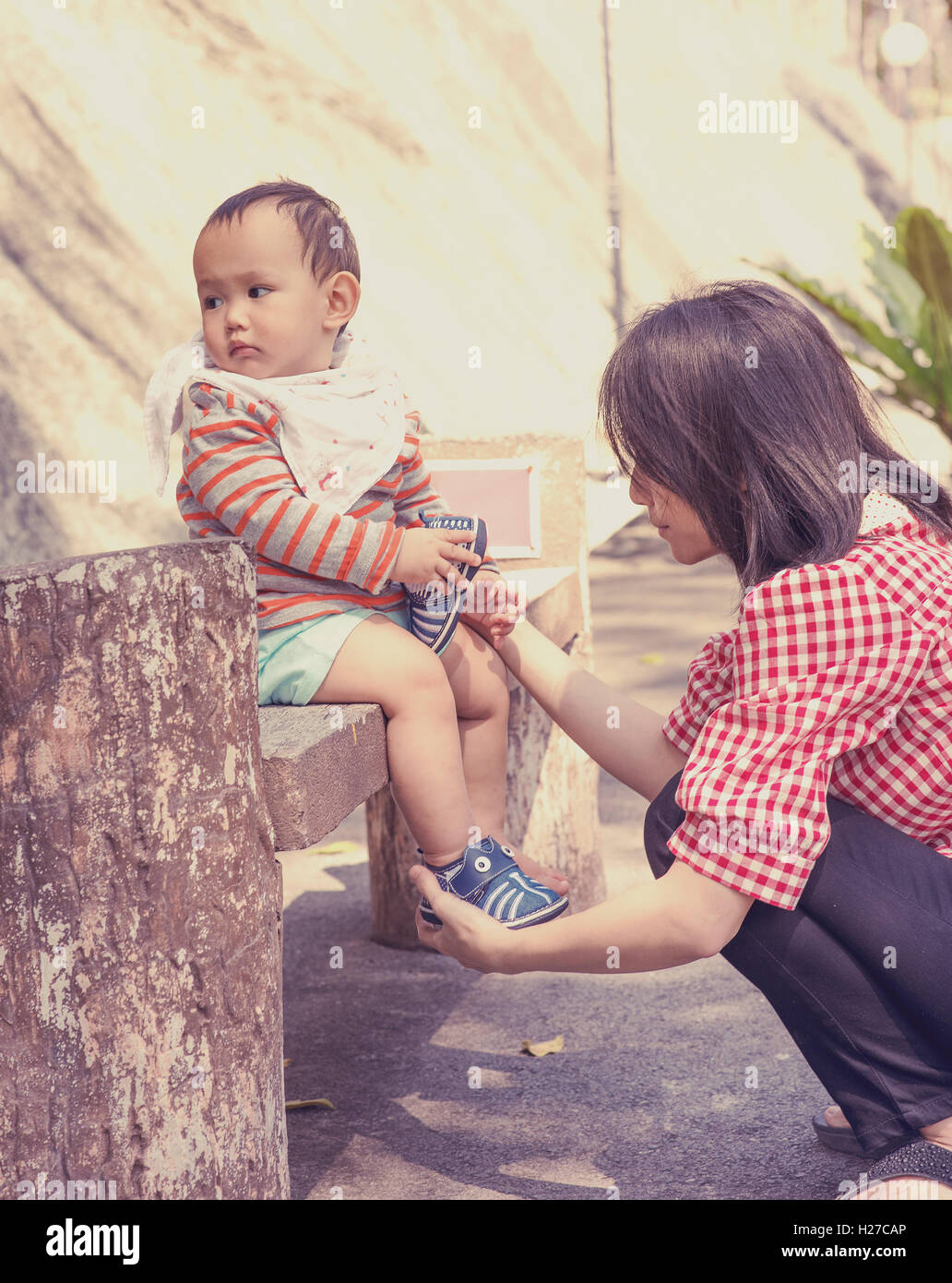 Asiatische Mutter tragen Schuh jungen in der Outdoor-park Stockfoto