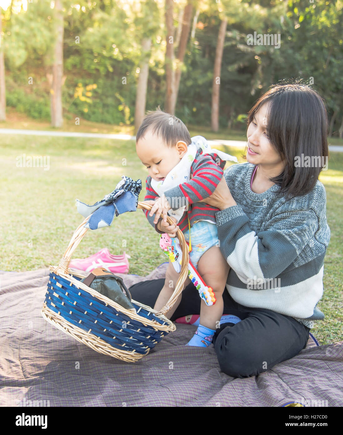 Mutter Baby halten, wenn Familie Picknick im park Stockfoto