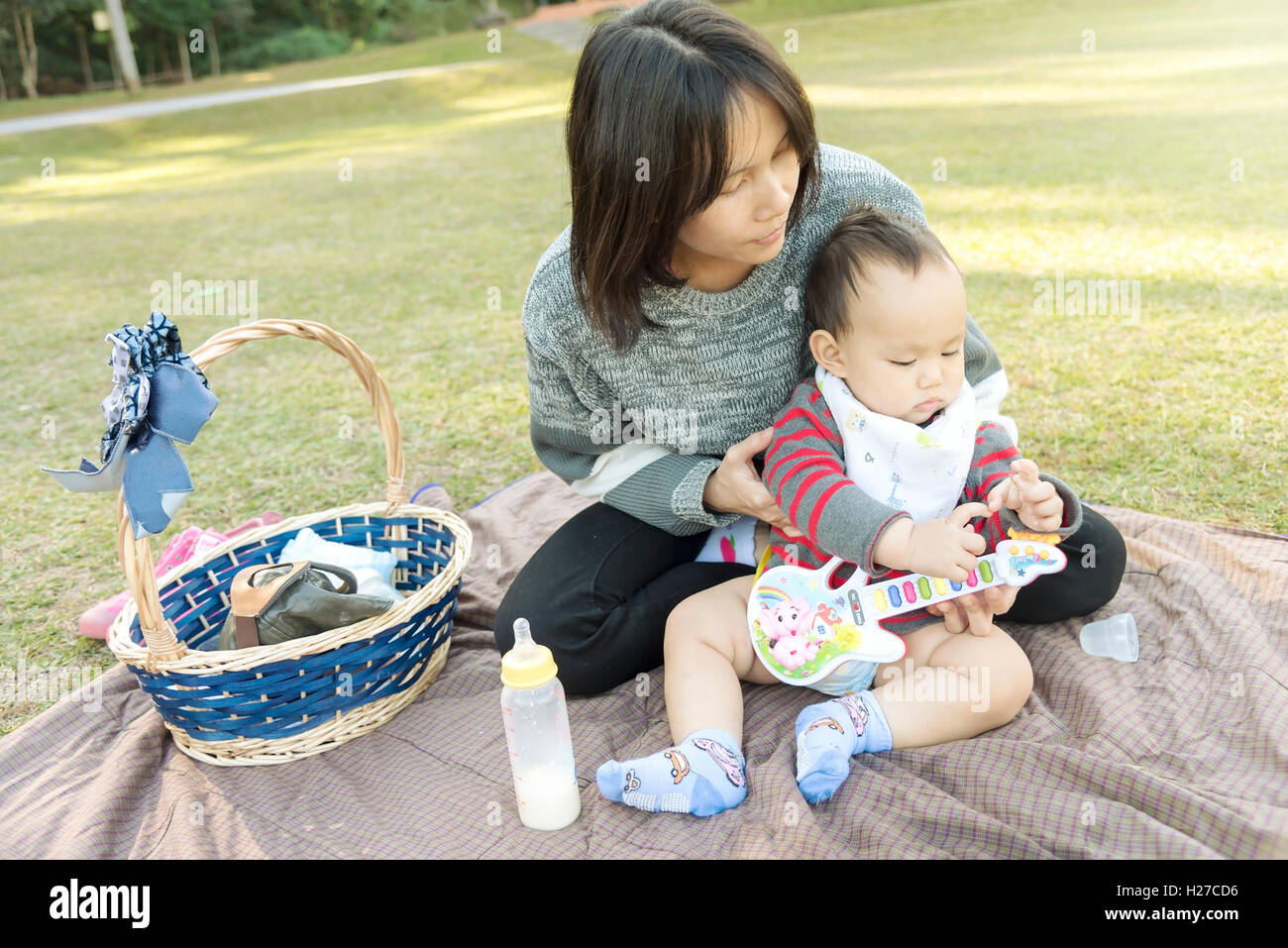 Mutter Baby halten, wenn Familie Picknick im park Stockfoto