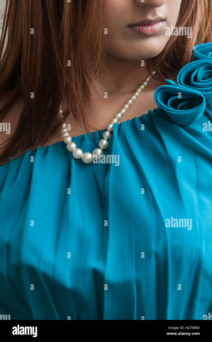 Nahaufnahme von eine junge Frau trägt ein blaues Kleid und Perlenkette Stockfoto