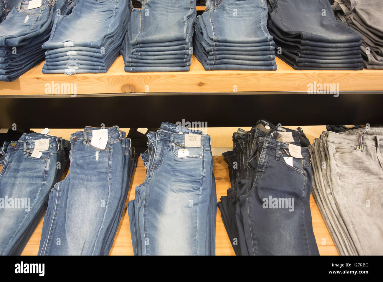 Store-Display, Jeans zusammengeklappt und gestapelt auf den Tischen Stockfoto