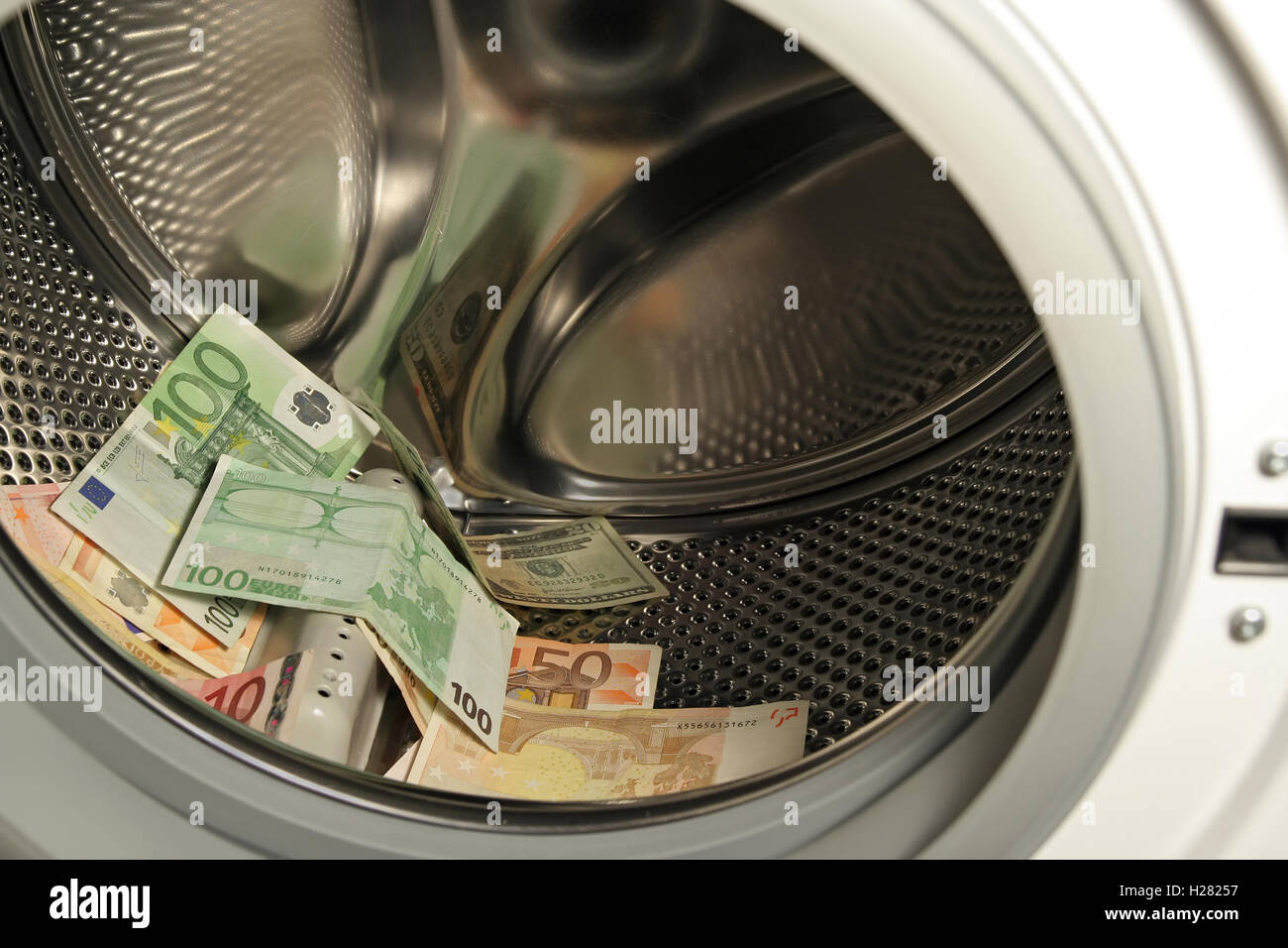 Geld in die Waschmaschine. Papier-Banknoten in der Wäscherei. Währung in der Waschmaschine. Stockfoto