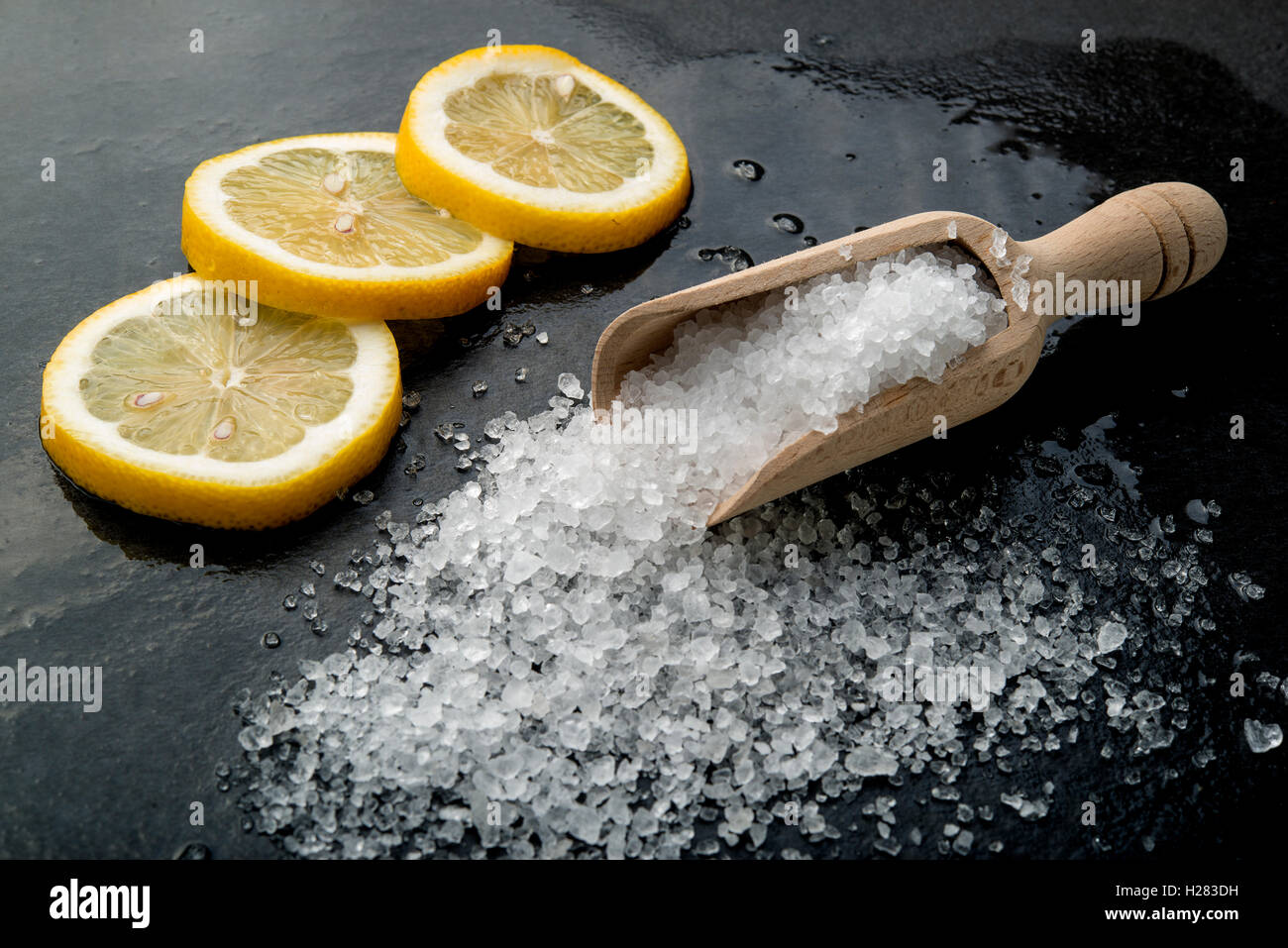 Zitrone und Salz auf einem schwarzen Brett Stockfoto