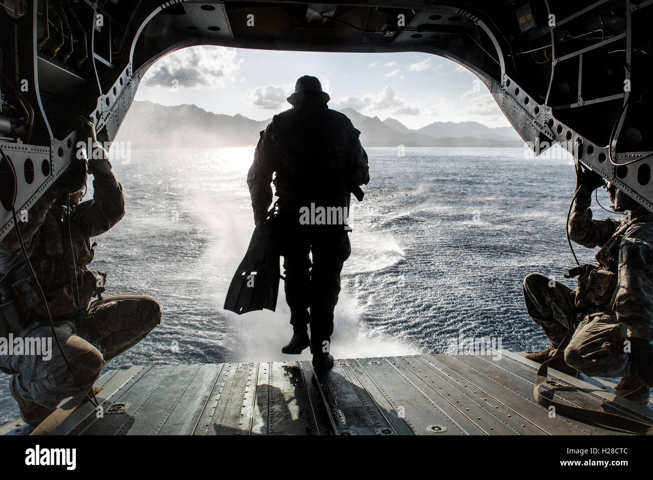 US Army Special Forces Soldat rennt der Rückseite der CH-47F Chinook Helikopter während einer Bekämpfung Dive Trainingsmission in Kaneohe Bay vor der Küste des Marine Corps Training Bereich Balges 16. März 2015 in der Nähe von Waimanilo, Hawaii. Stockfoto