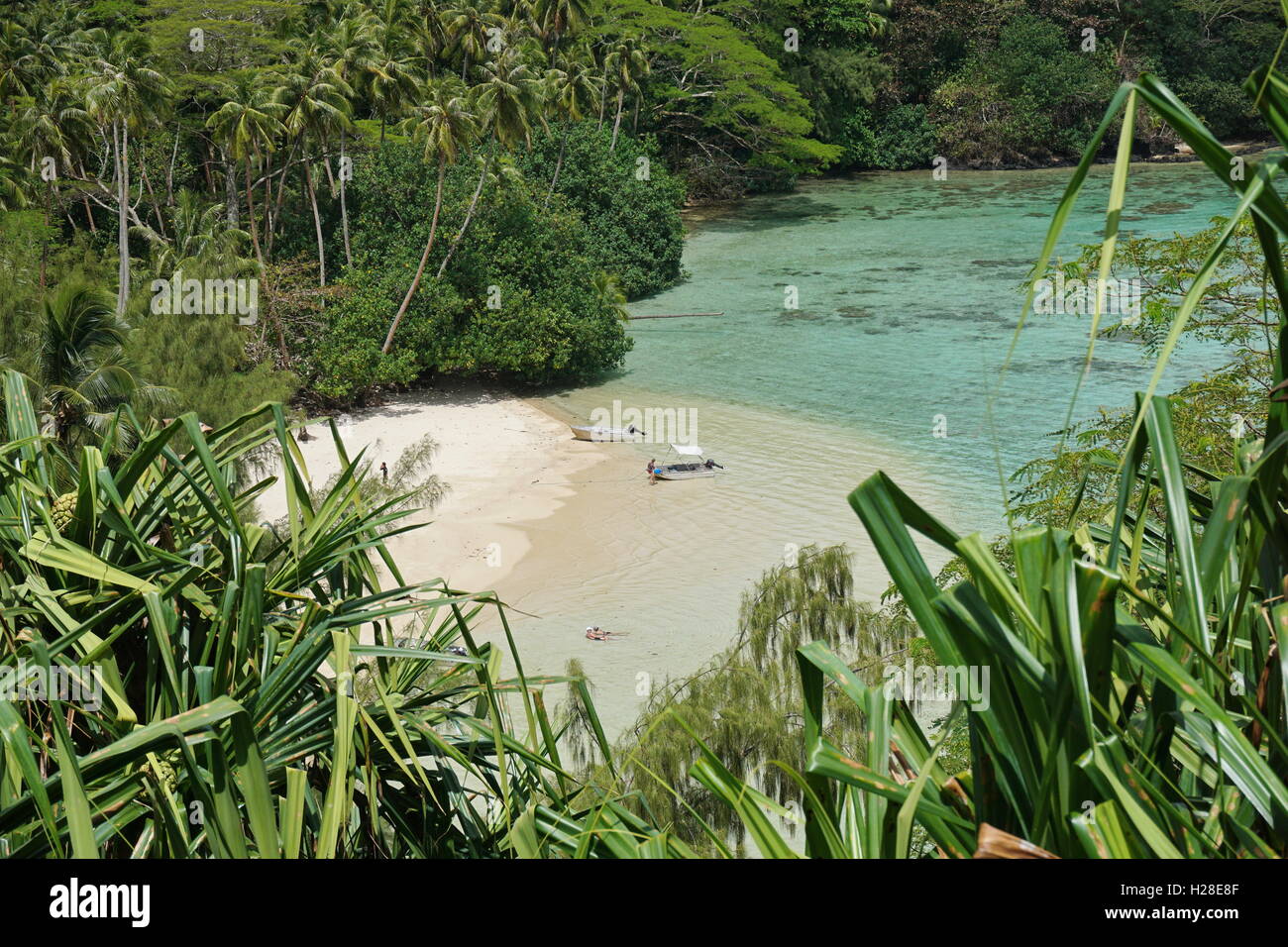 Einem einsamen tropischen Strand mit üppiger Vegetation und zwei Boote mit wenigen Touristen, Huahine Insel, Pazifik, Französisch-Polynesien Stockfoto