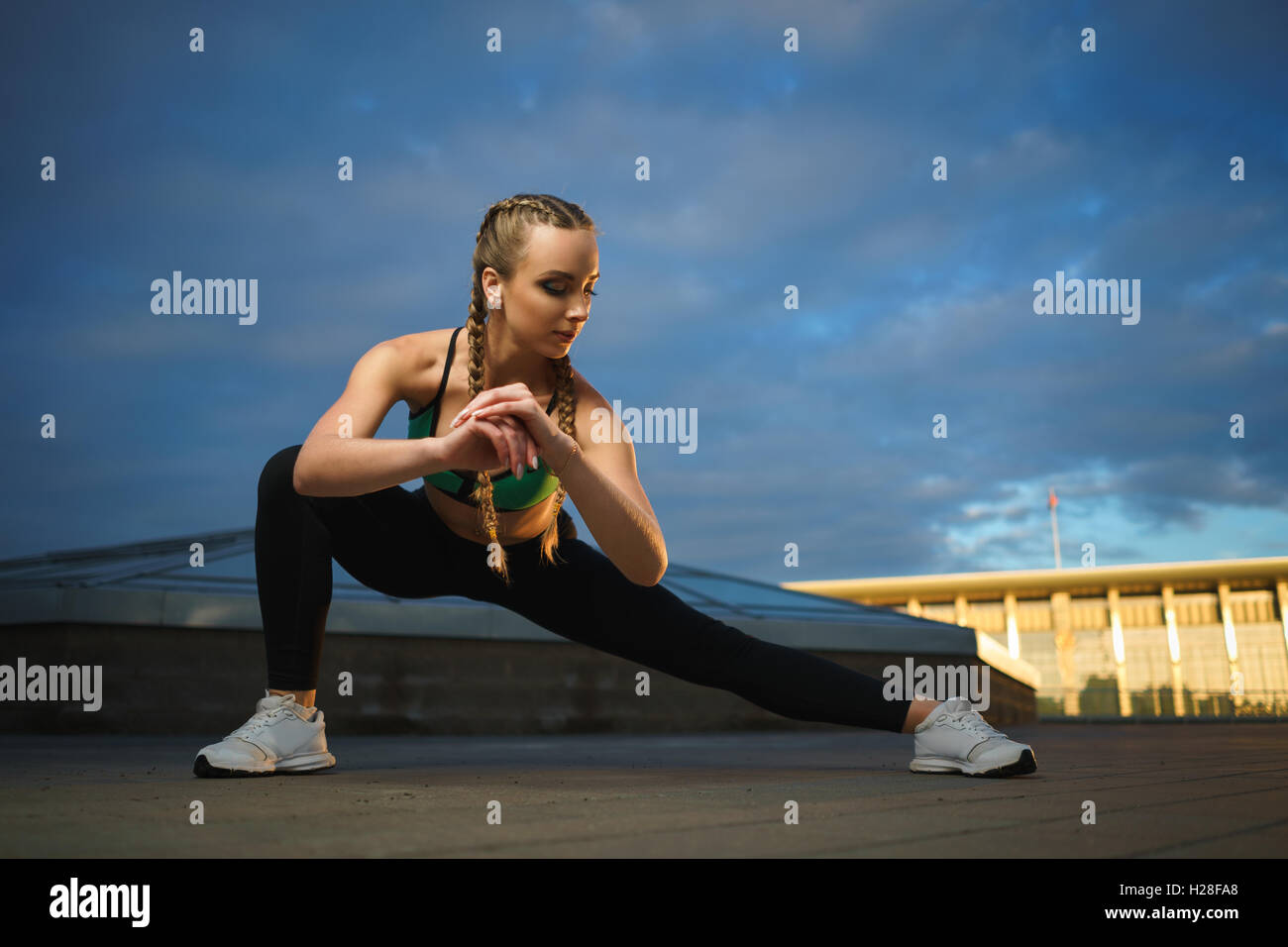 Konzept: gesunde Lebensweise, Sport. Attraktive glückliches Mädchen Fitness Trainer Stretch outdoor-Training im modernen urbanen Innenstadt d Stockfoto