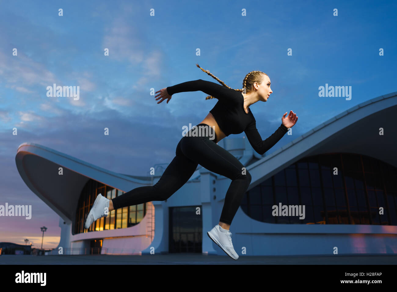 Konzept: gesunde Lebensweise, Sport. Attraktive glückliches Mädchen Fitness Trainer laufen outdoor-Training im modernen urbanen Innenstadt durin Stockfoto