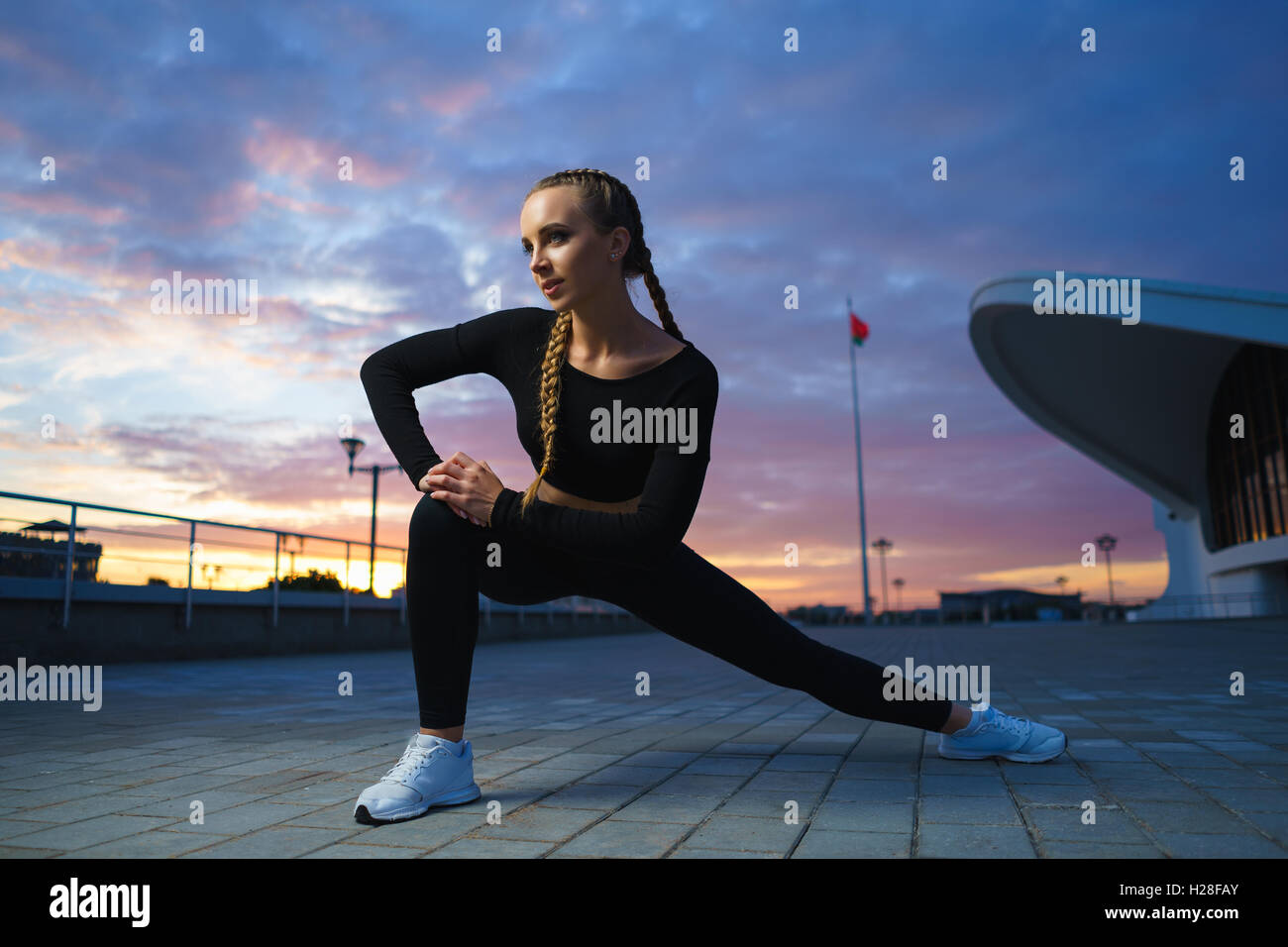 Konzept: gesunde Lebensweise, Sport. Attraktive glückliches Mädchen Fitness Trainer Stretch outdoor-Training im modernen urbanen Innenstadt d Stockfoto