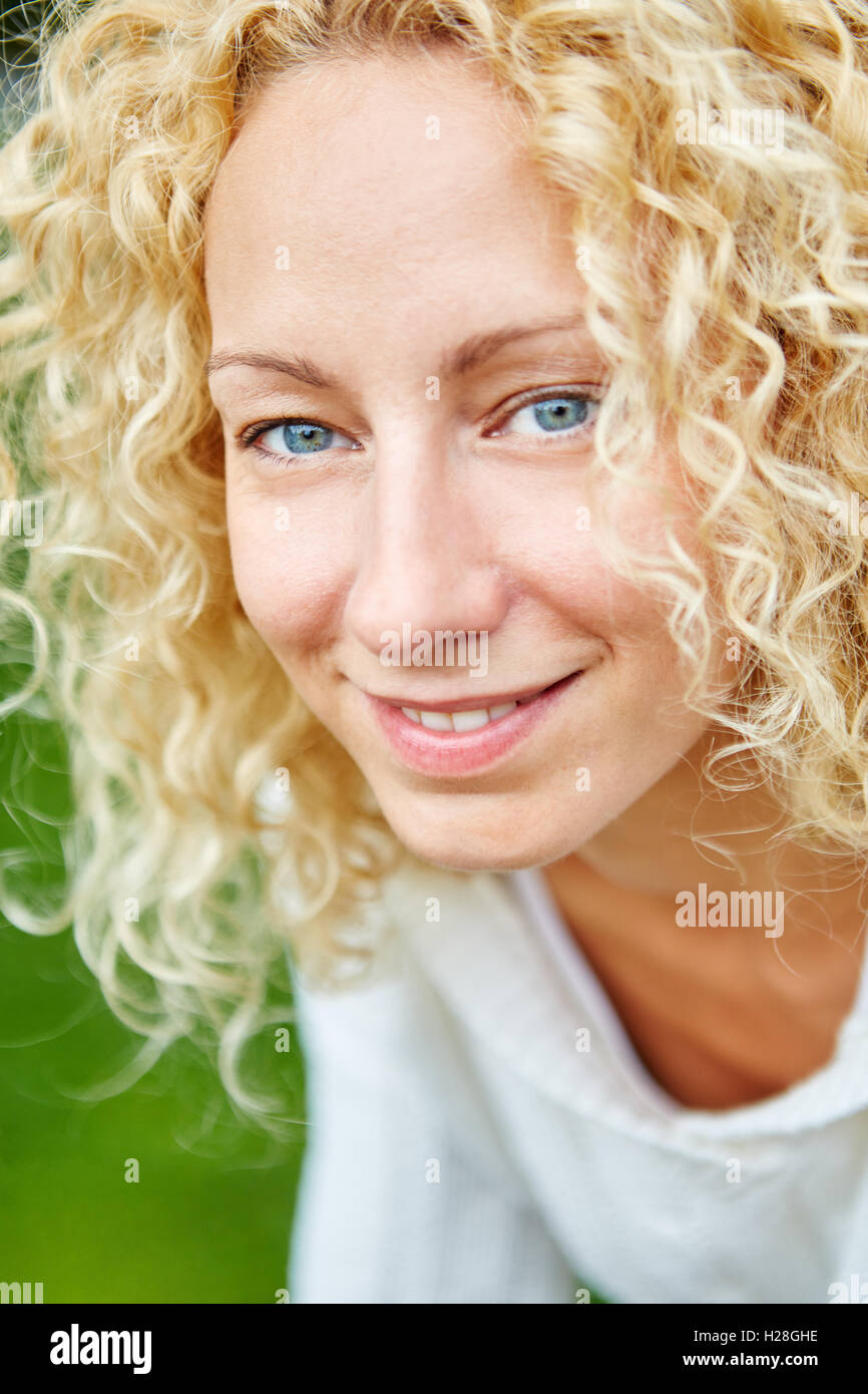 Porträt von blonden glückliche junge Frau mit locken Stockfoto