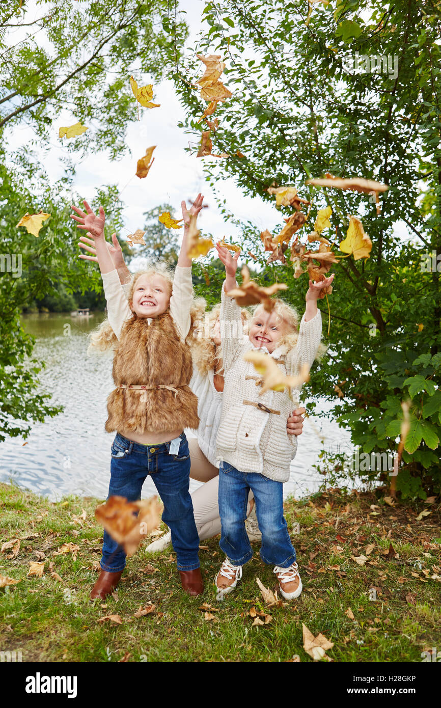 Aktive Kinder Spaß im Herbst, die Blätter in die Luft werfen Stockfoto