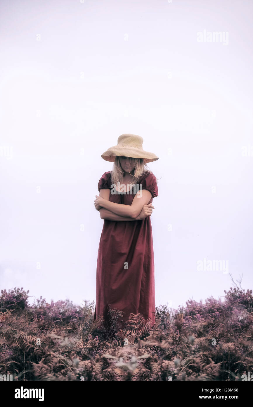eine Frau in einem roten Kleid steht in die Heide Stockfoto