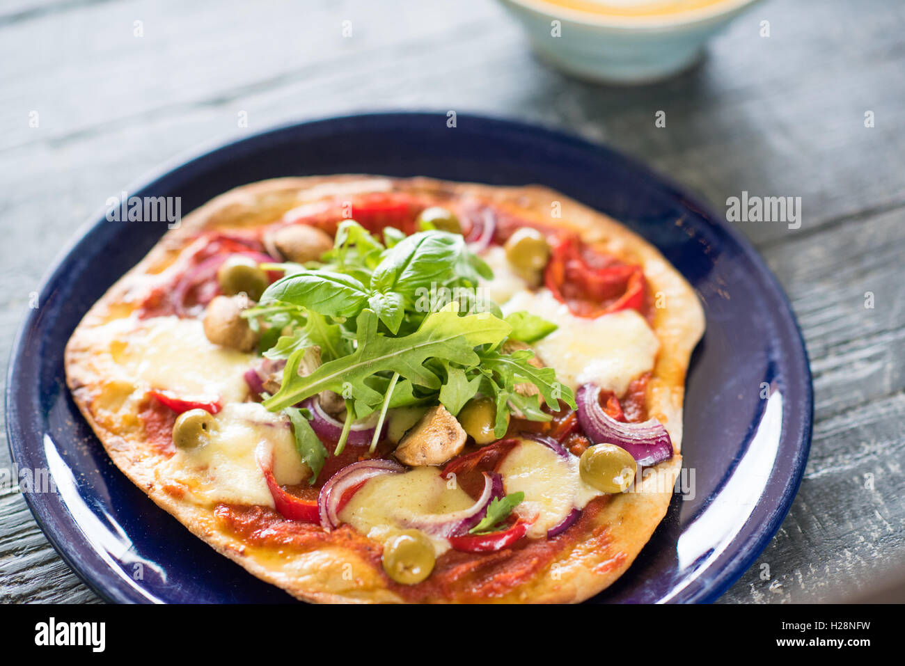 Eine rustikale Pizza auf Holztisch Stockfoto