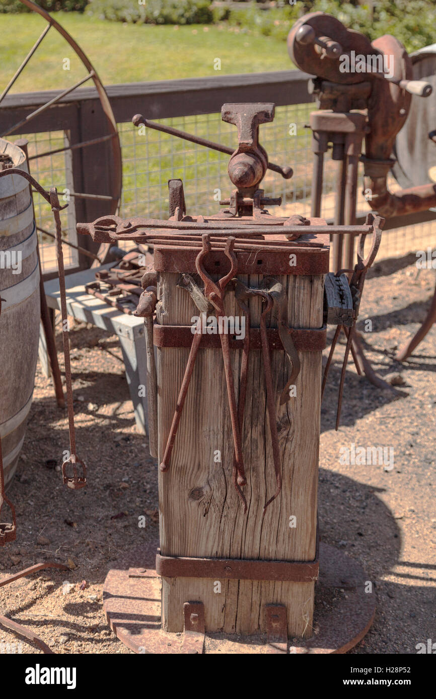 Alten altmodischen Schmied Eisenwerkzeuge auf einem beunruhigten, antike Holzständer Stockfoto