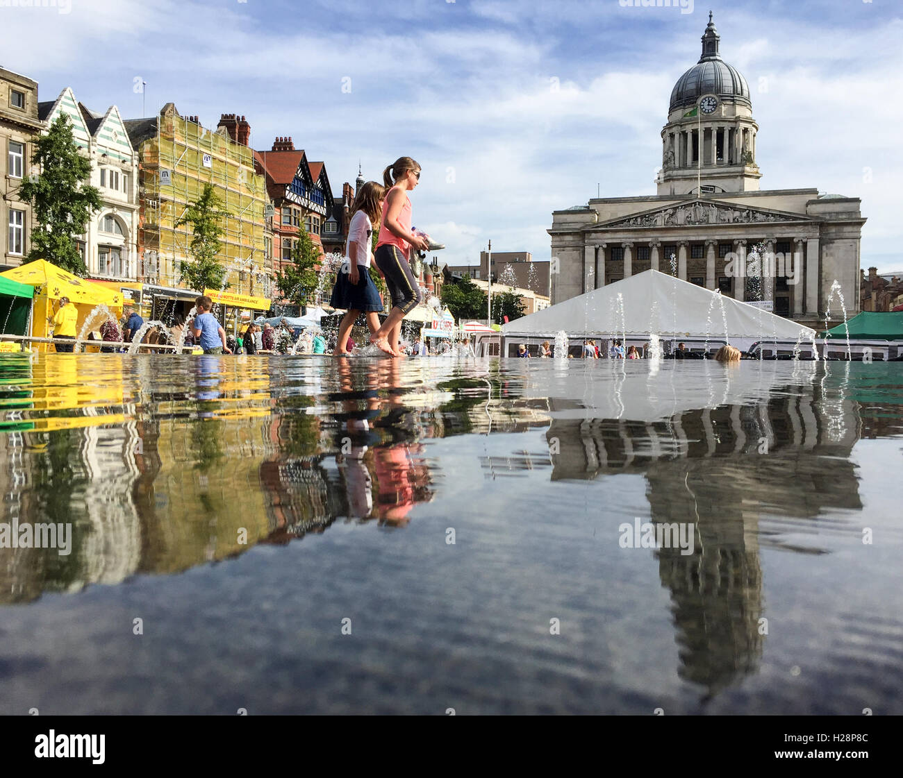 Mädchen spielen im Wasser, Marktstände verschiedene hinter Marktplatz, Nottingham Stadtzentrum Stockfoto
