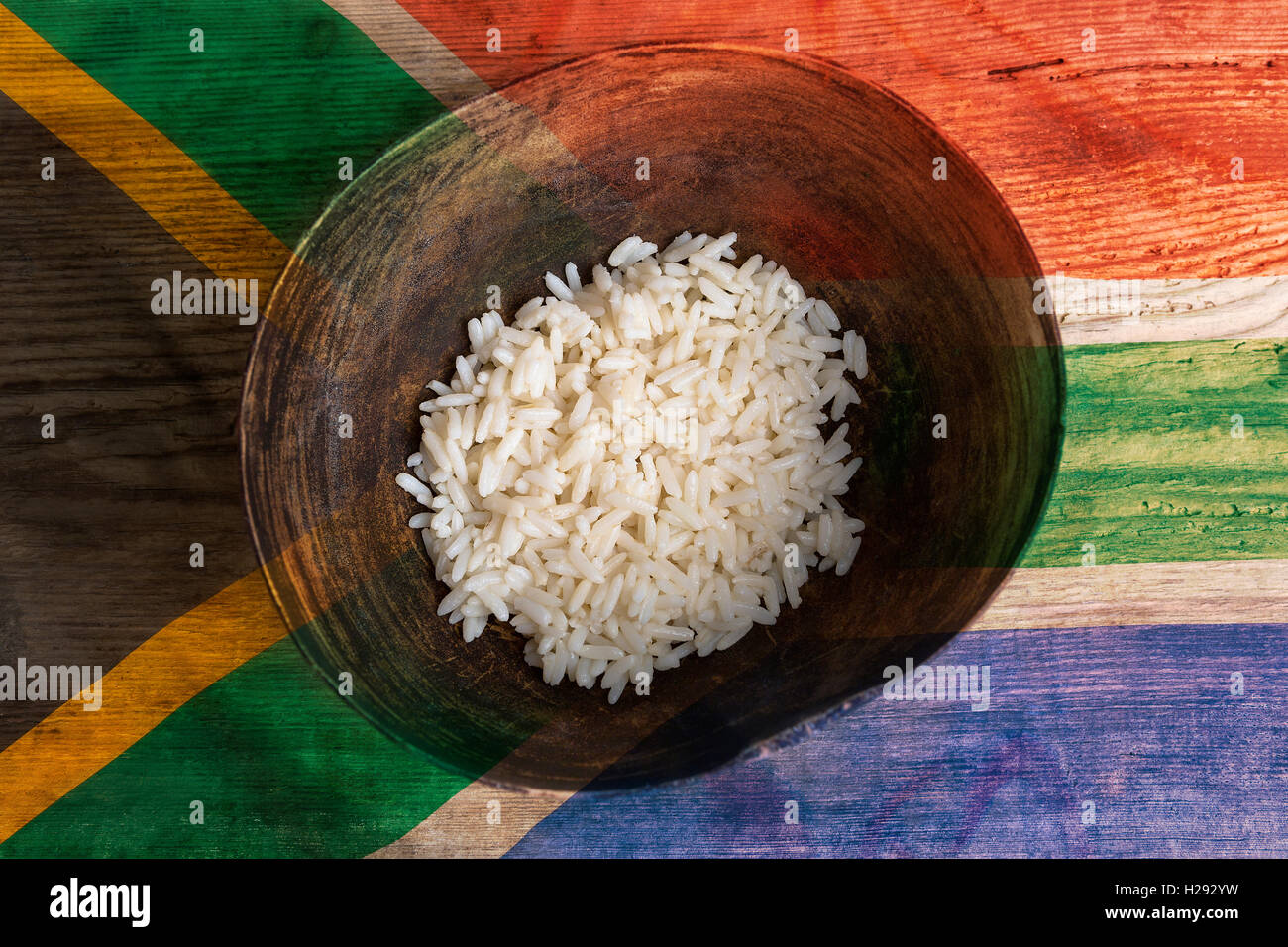 Armut-Konzept, Schüssel Reis mit Südafrika Flagge auf hölzernen Hintergrund Stockfoto