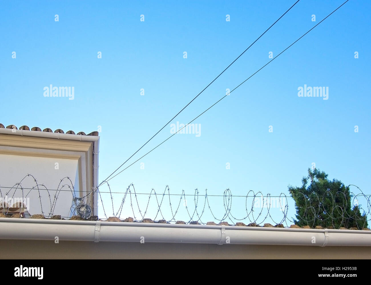 Stacheldraht gegen blauen Himmel, Hintergrund für Soziales, Grenze, Einwanderung, Nationalismus oder Politik. Stockfoto