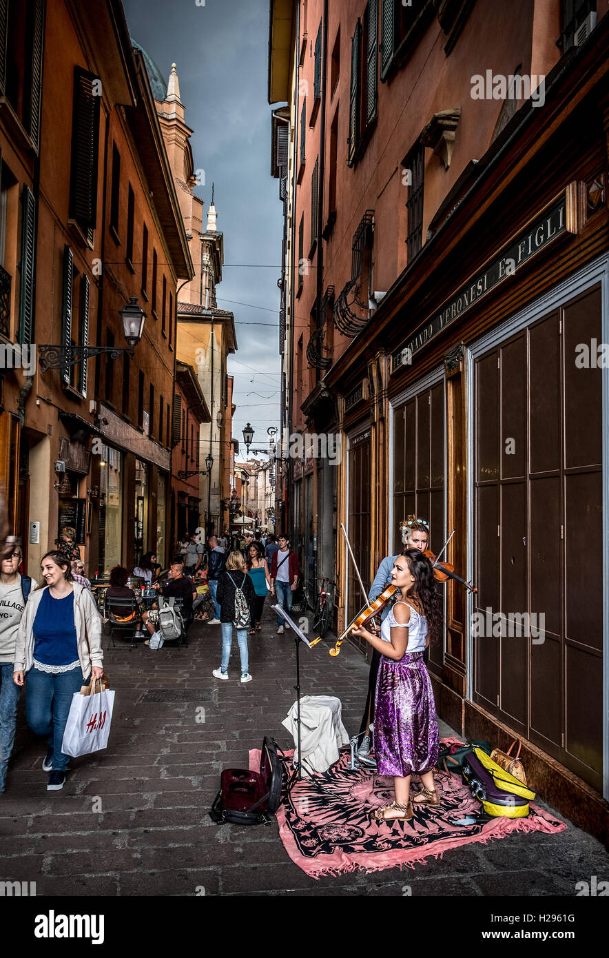 zwei Buskers Geiger führen für die Passanten im historischen Bezirk von Bologna vor Sturm Stockfoto