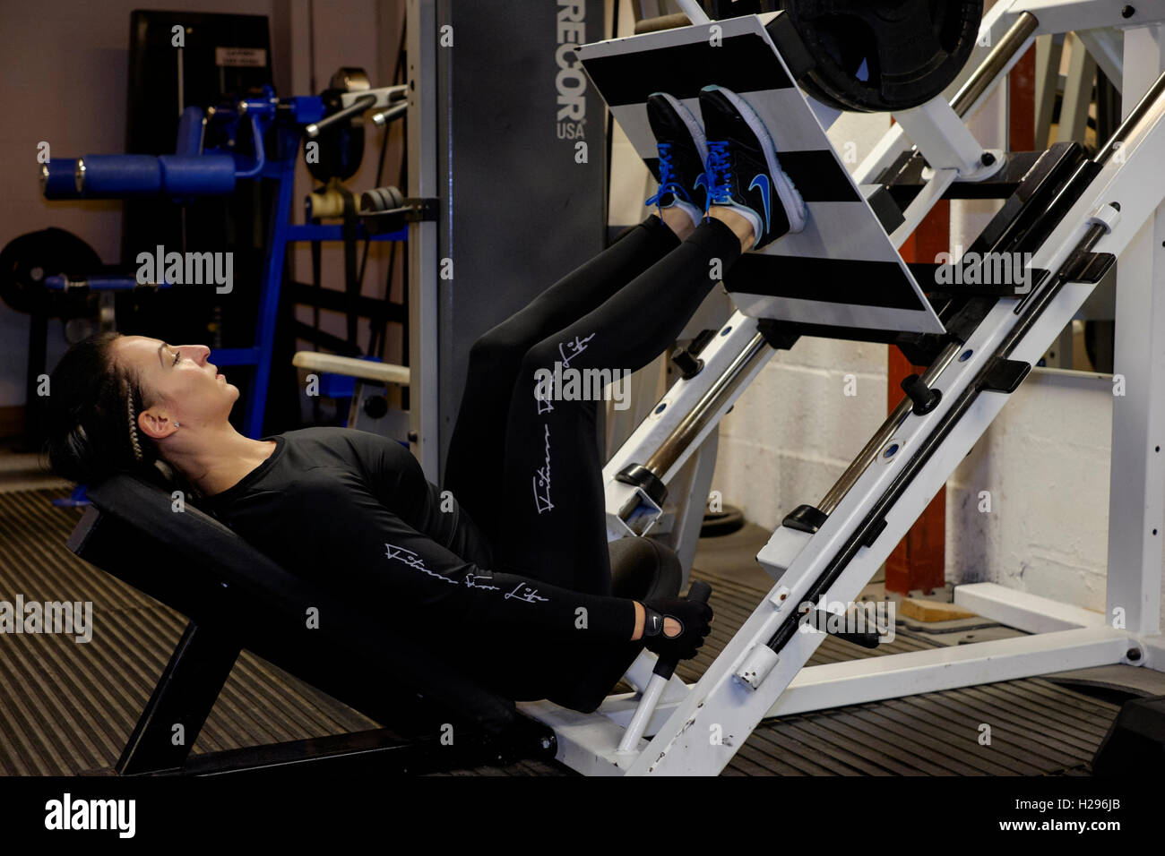 junge Frau, die Stärkung der Beine trainieren in einem Fitness-Studio-England-Vereinigtes Königreich Stockfoto