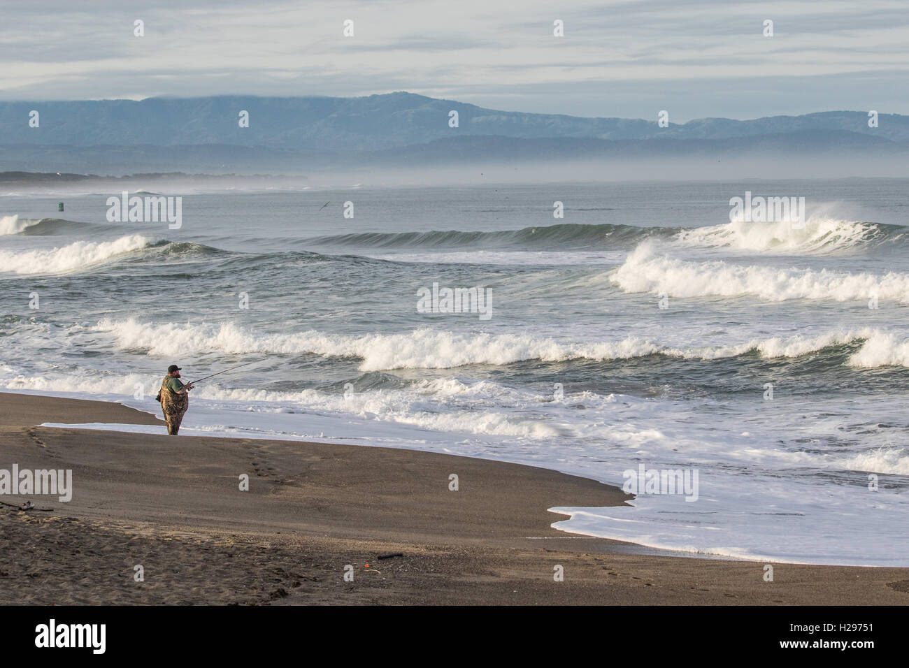 Ein Fischer versucht sein Glück Fischen im kalten Wasser von Nordkalifornien. Moss Landing ist ein beliebter Ort für Erholung. Stockfoto