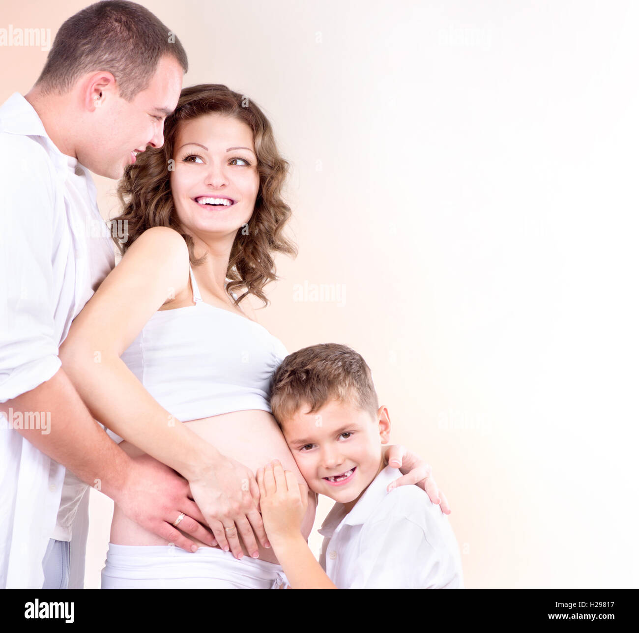 Glückliche Familie erwartet Baby. Kinder hören schwangeren Bauch Stockfoto
