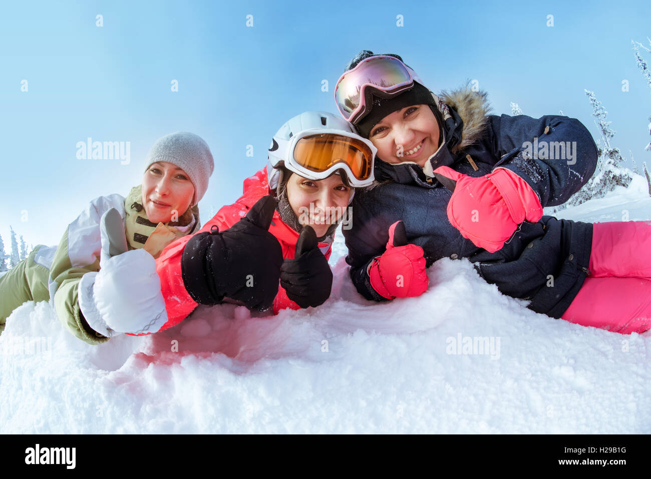 Snowboarder posiert auf blauen Himmel Hintergrund in Bergen Stockfoto