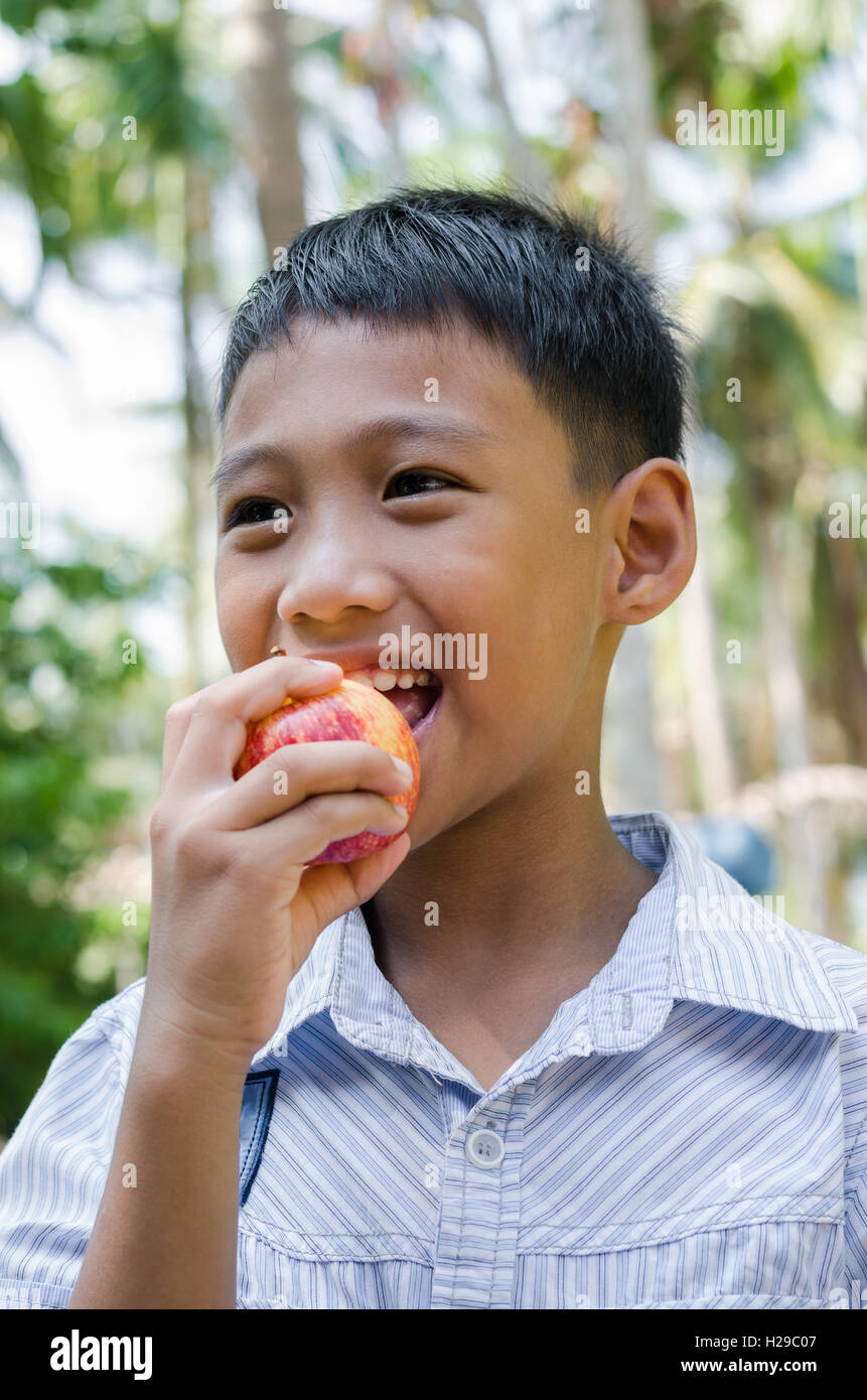 Asiatische Kind genießen Essen Apfel. Stockfoto