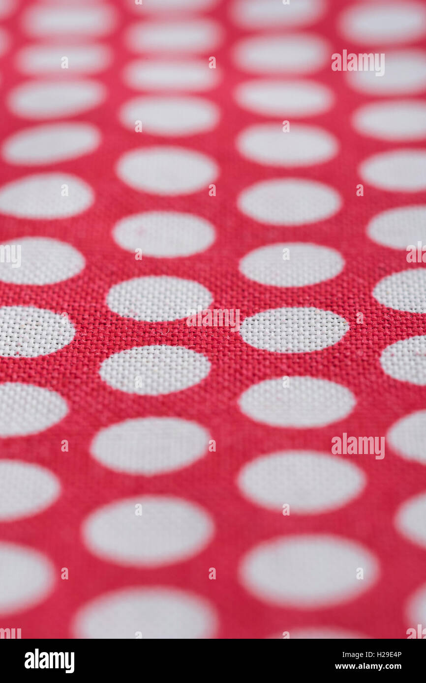Abstrakt rot-weiß gepunkteten Baumwolle material-Spots geht zurueck in die Ferne. Schmale DoF-Makro-shot. Konzept "Internationale Dot Tag' und Dotty. Stockfoto
