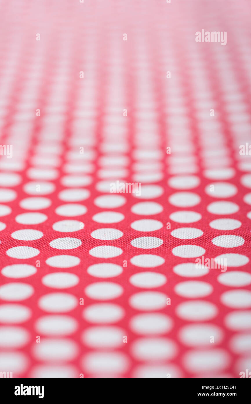 Abstrakt rot-weiß gepunkteten Baumwolle material-Spots geht zurueck in die Ferne. Schmale DoF-Makro-shot. Konzept "Internationale Dot Tag' und Dotty. Stockfoto