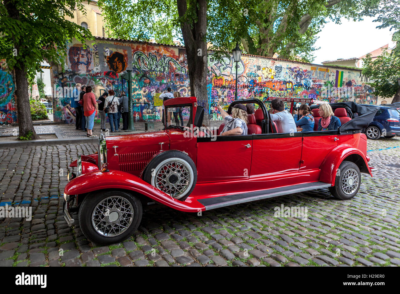 John Lennon Mauer Prag Menschen in einem alten Oldtimer Prag Stadtbesichtigung Stockfoto