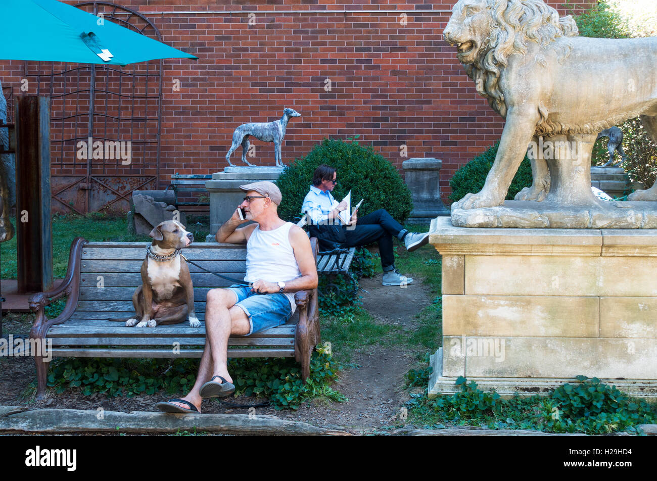 Senior Mann mit seinem Pitbull Hund entspannen in Elizabeth Street Garten in Nolita Stockfoto