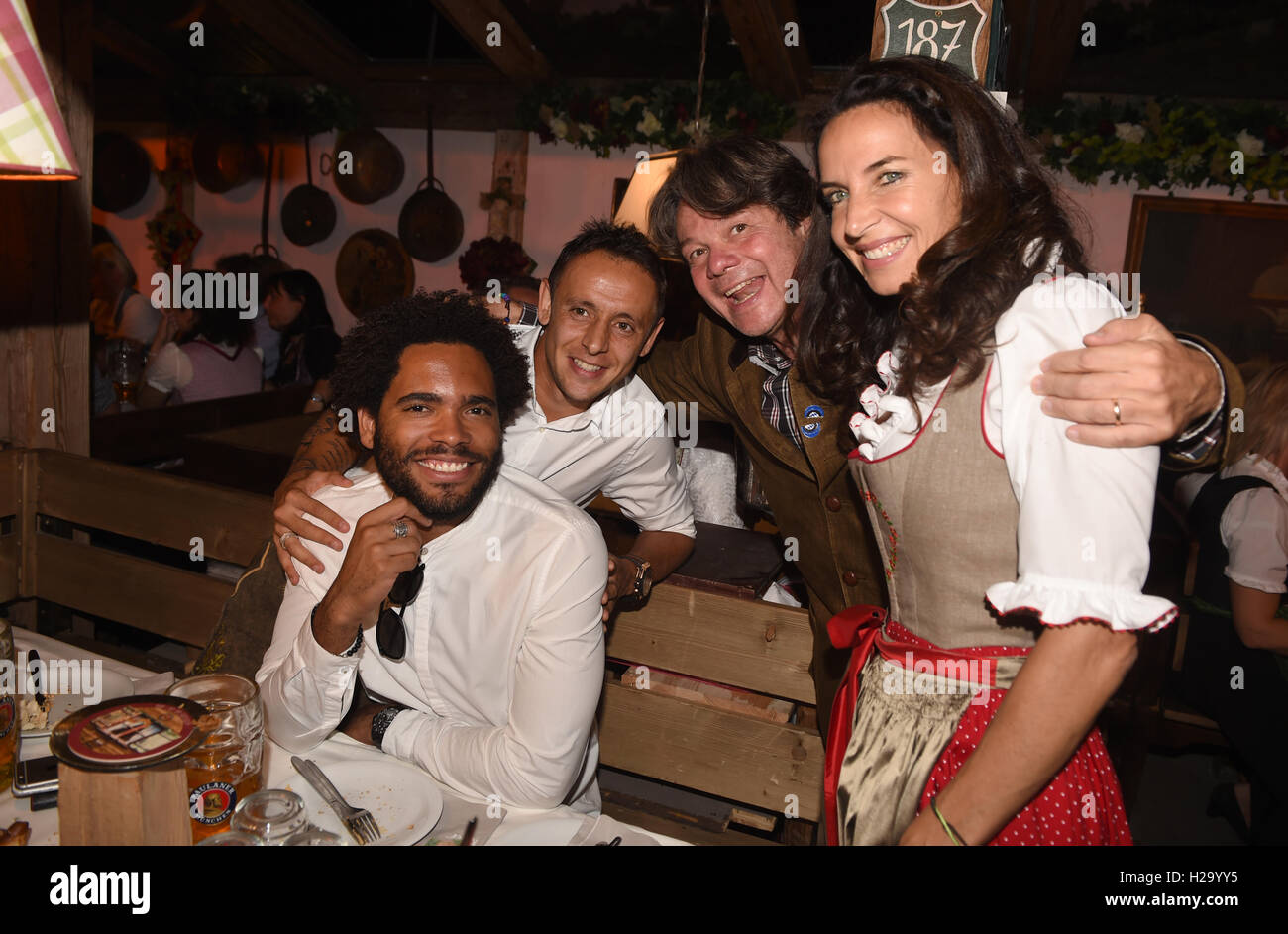 München, Deutschland. 25. September 2016. Fußballspieler vom FC Bayern, Rafinha (2.v.l) und Thiago Santos (Cousin von Dante, L) sitzen mit Oktoberfest-Wirt Michael Kaefer und seine Frau Clarissa in der Kaefer-Zelt auf dem Oktoberfest in München, Deutschland, 25. September 2016. Das 183. Münchner Oktoberfest findet vom 17. September bis 3. Oktober 2016. Foto: Felix Hoerhager/Dpa/Alamy Live News Stockfoto