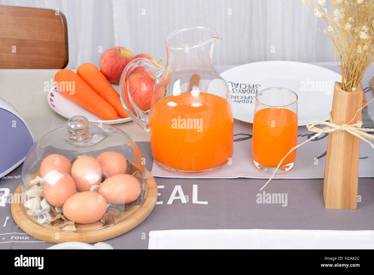 Gesundes Frühstück, Eiern, Obst und Saft am Esstisch im Zimmer. Stockfoto