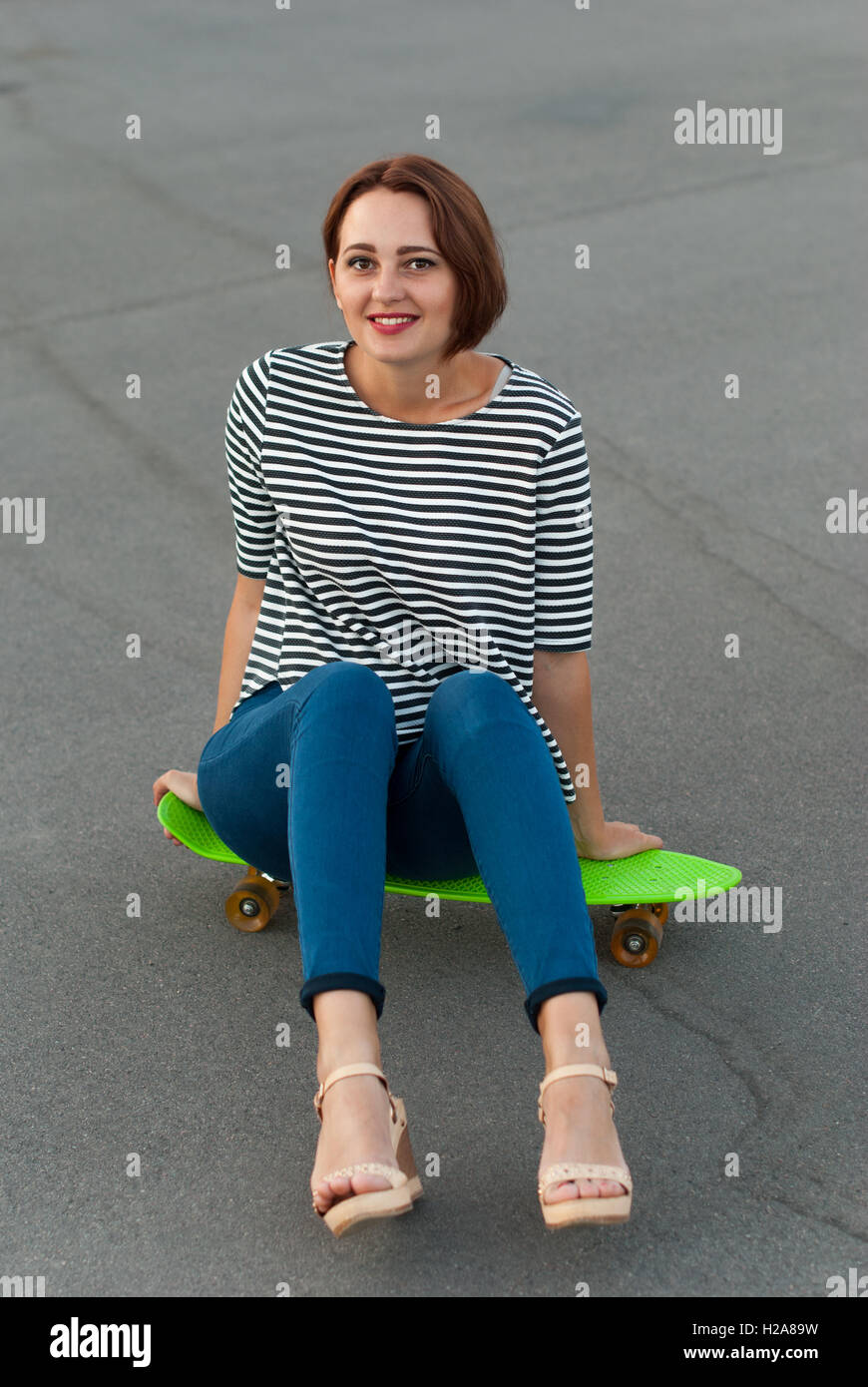 Attraktives Mädchen mit einem Skateboard. Stockfoto