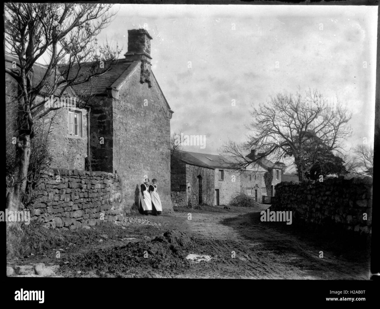 Zwei Mädchen im Dienst machen Sie eine Pause in der Sonne. Rustikale Szene c 1910. Foto von Tony Henshaw Stockfoto