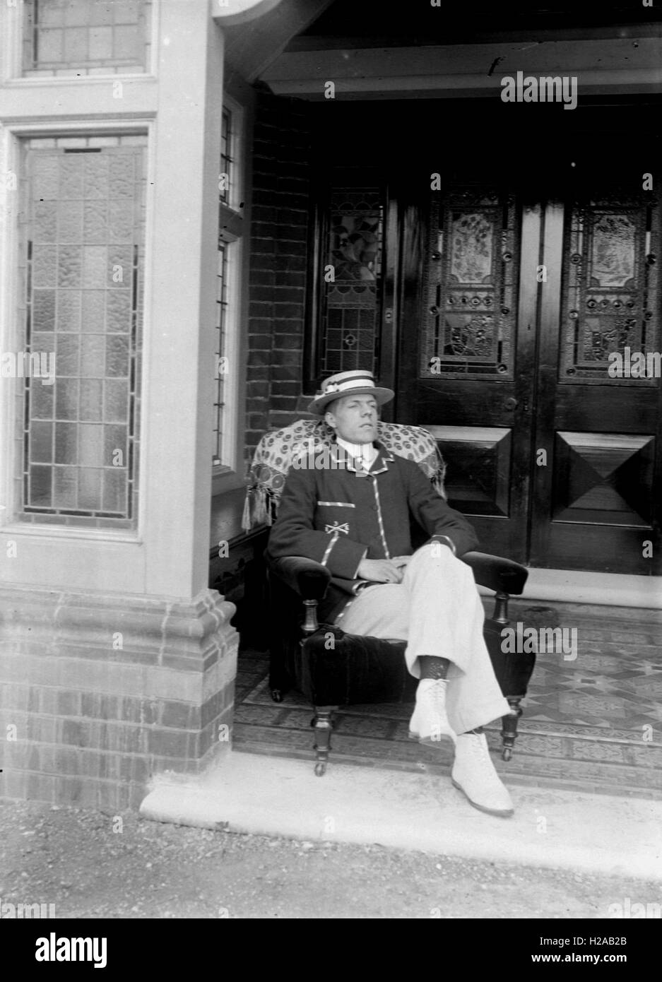 Kluger Mann mit Strohhut Hut posiert vor seiner Haustür. C1920. Foto von Tony Henshaw Stockfoto