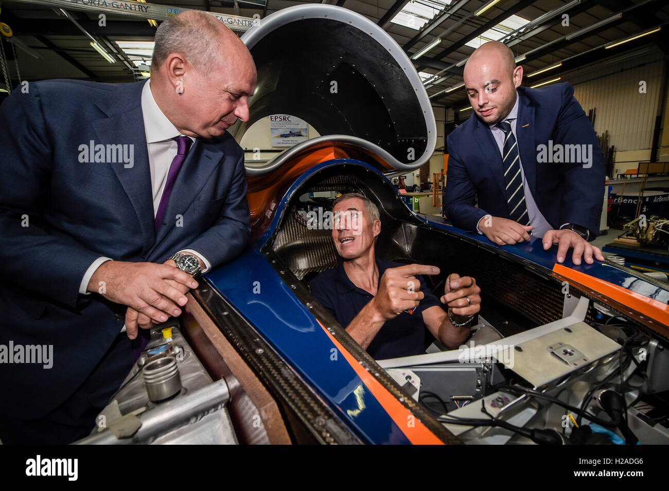 Kampfpilot und Fahrer Andy Green sitzt im Cockpit des Bloodhound SSC (Überschall Auto) erklärt er die Steuerelemente, Frank Klaas, Director of International Communications für Geely, links und Ash Sutcliffe, PR-Managerin für Geely, rechts, nach der Ankündigung, die Bloodhound-Projekt sind Partnerschaften mit führenden chinesischen Automobilkonzern Zhejiang Geely Holding Group (ZGH) in eine 3-Jahres-Vertrag, die sowohl technische als auch finanzielle bieten wird, das Projekt unterstützen und fördern seine inspirierende Programm im Laufe Asien. Stockfoto