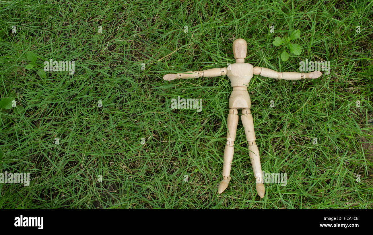 menschlichen Holzfigur legen auf Grasgarten entspannen Stockfoto