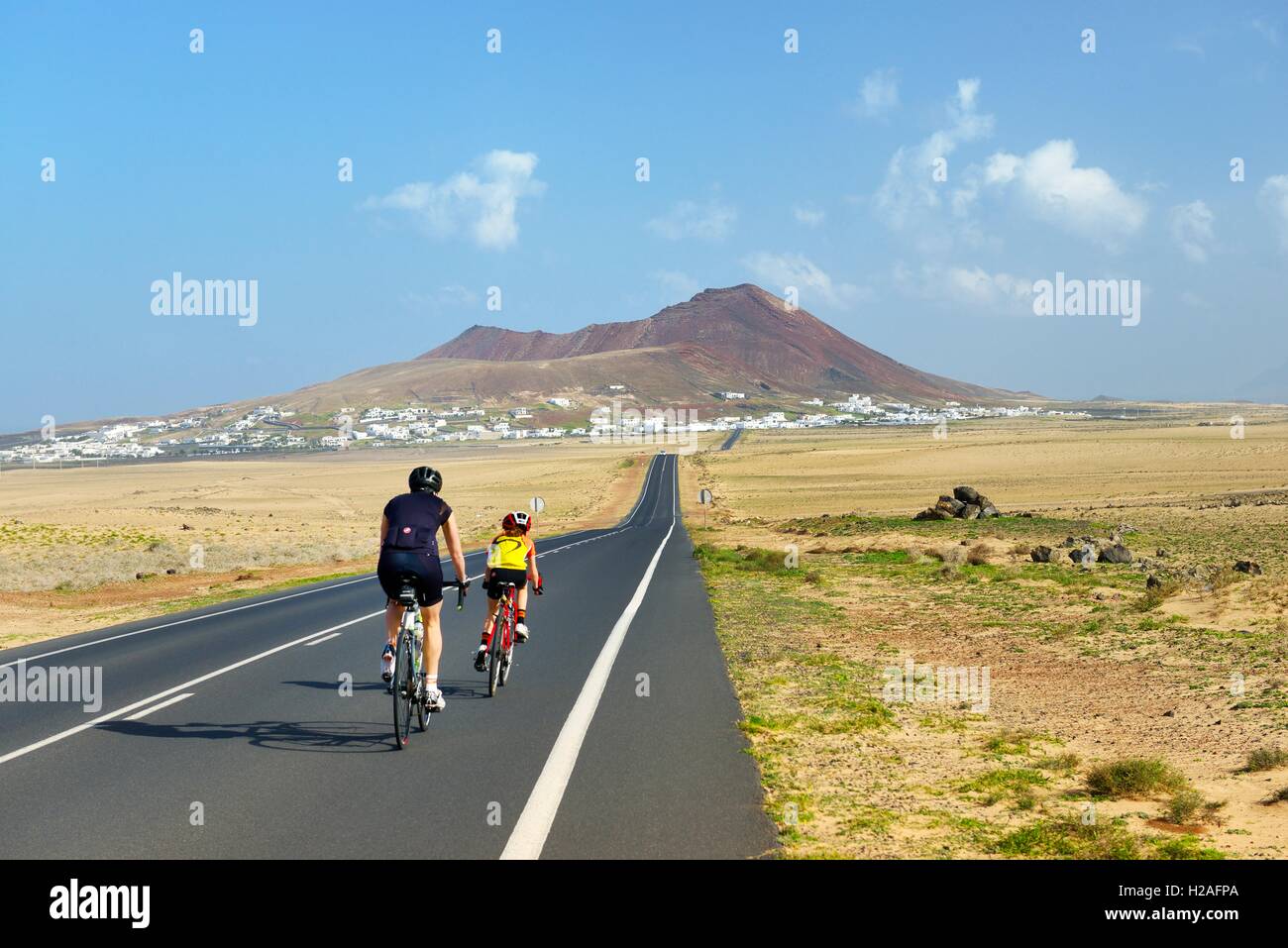 Radfahren auf der LZ-401 Straße in Richtung Vulkankegel ragen Dorf Soo. Teguise, Lanzarote, Kanarische Inseln, Spanien Stockfoto